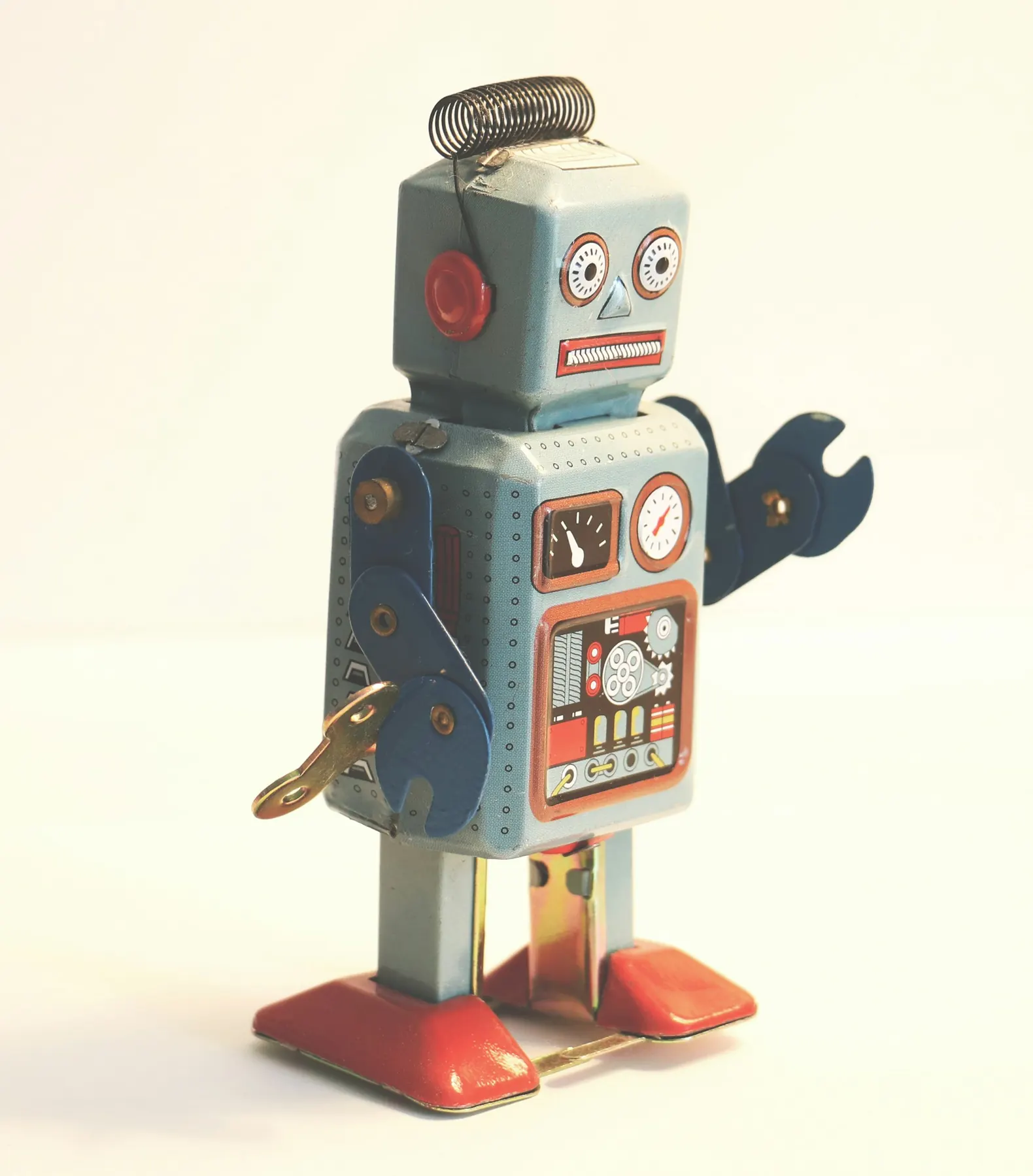 Robot en tôle bleu clair avec clé de remontage sur fond crème
