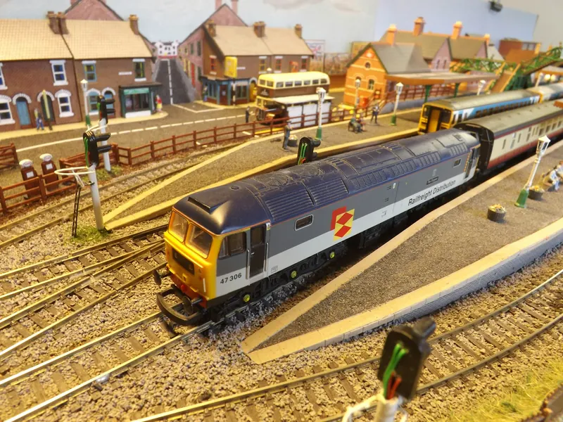 Train miniature coloré avec locomotive diesel et petites maisons