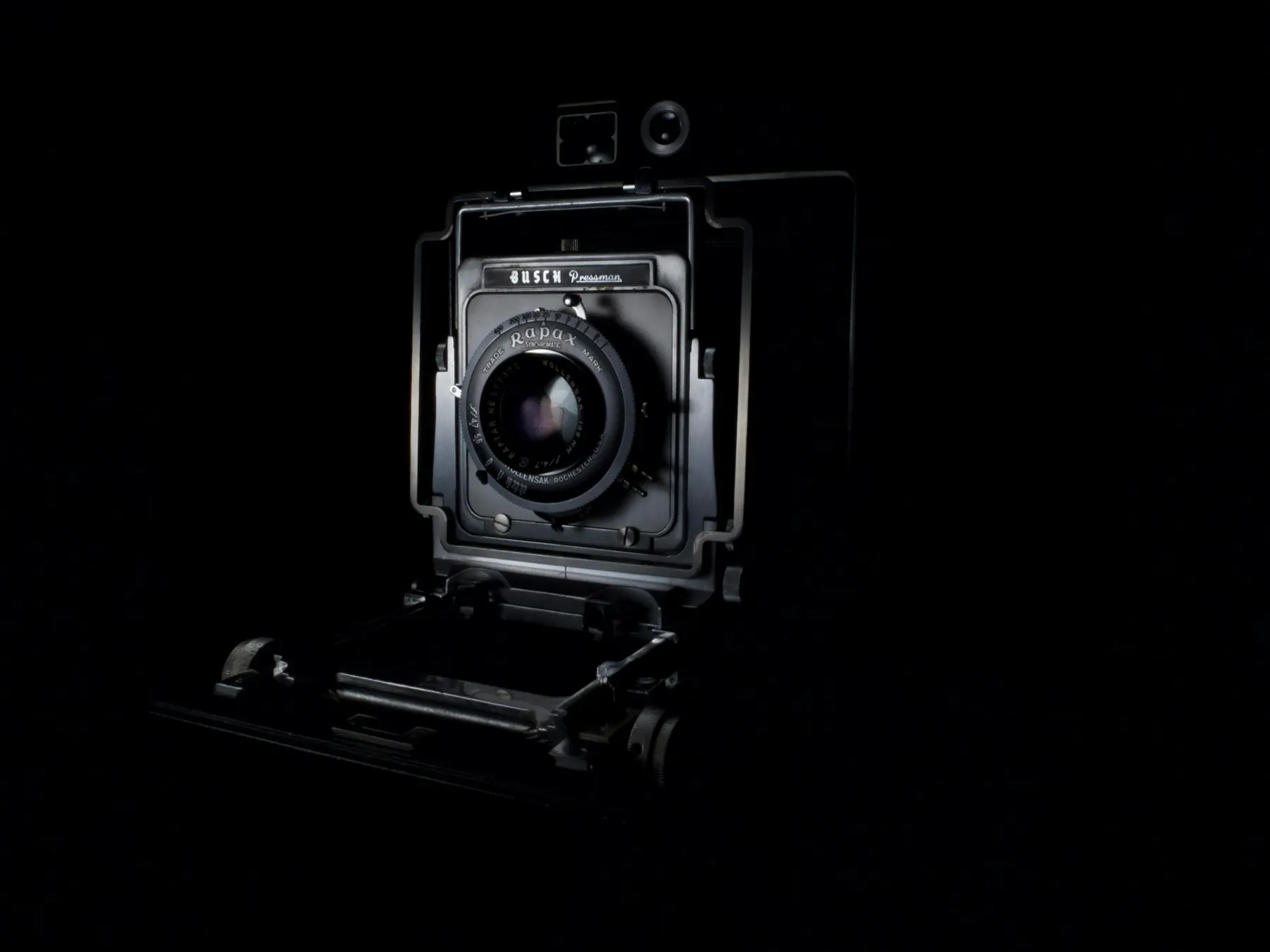 Appareil photo avec grand objectif devant un fond noir
