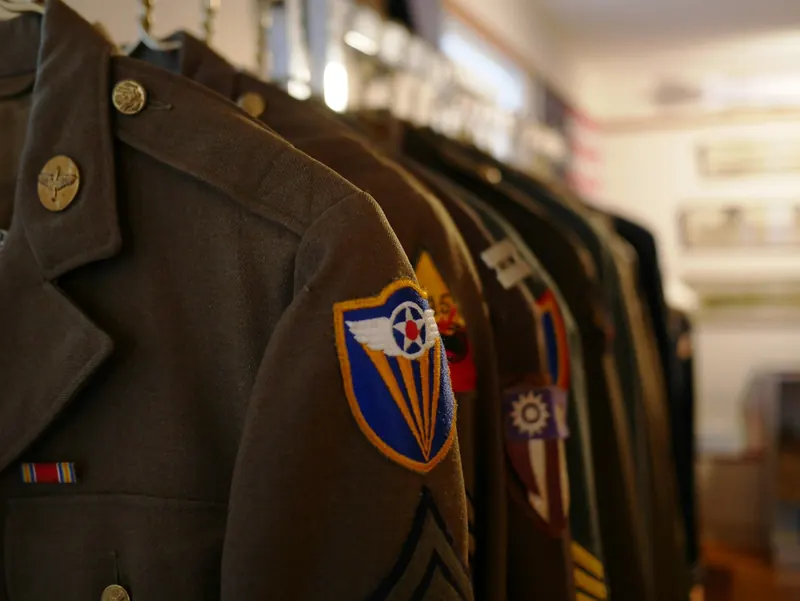 Vestes d’uniforme vert olive sur une tringle à vêtements